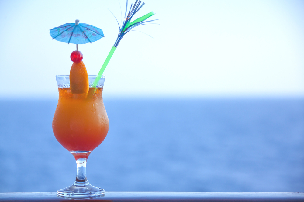 Photo of a cocktail drink on a banister.  A drink you might get with the Carnival Cheers package.