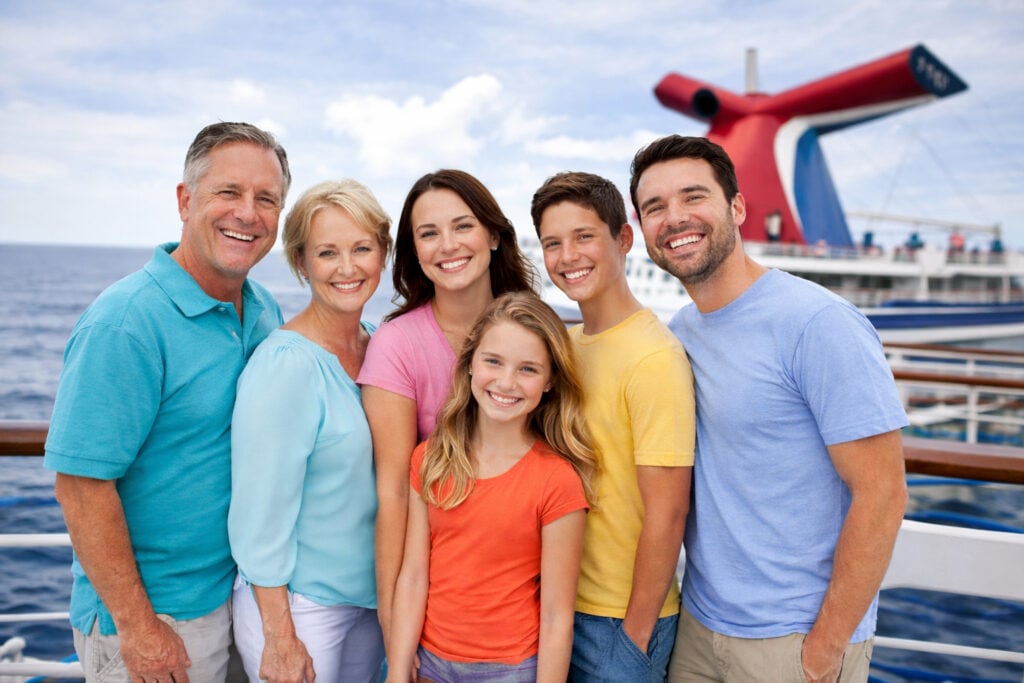 Multigenerational family walking on a cruise ship deck, illustrating the Carnival Cruise Line minor policy and cabin planning for families traveling together.